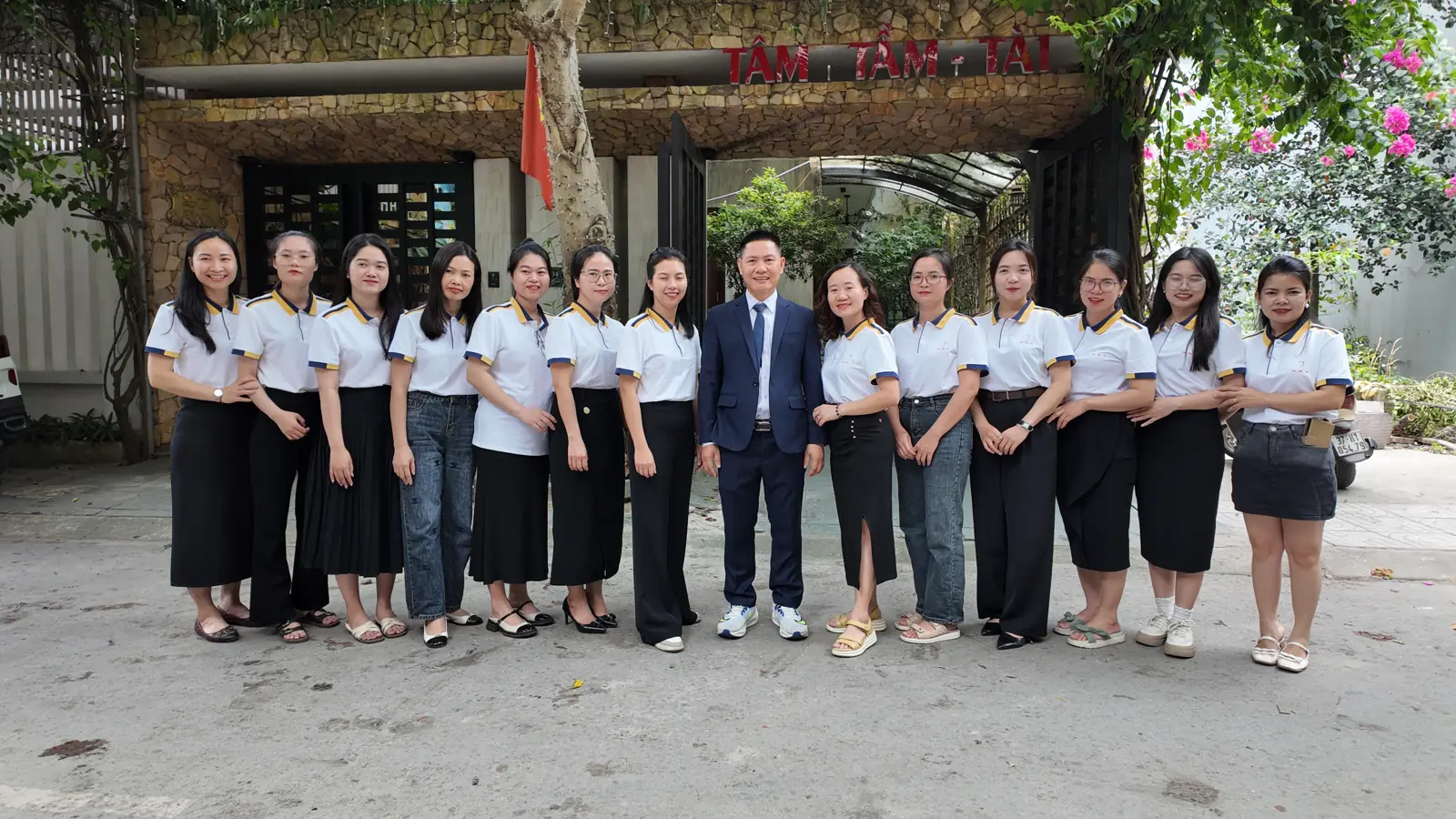 Tập thể nhân viên Tâm - Tầm - Tài trước trụ sở công ty