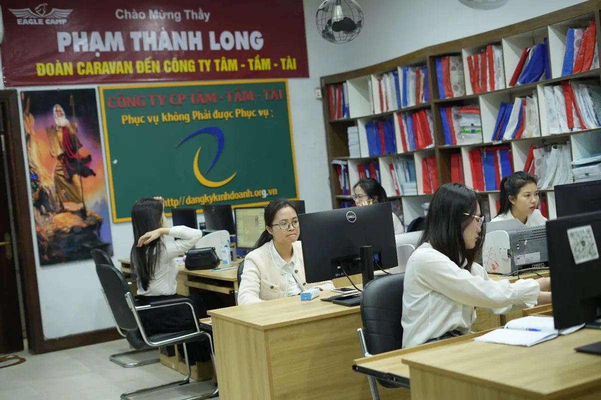 Nhân viên ngồi máy tính trong văn phòng Tâm - Tầm - Tài, kệ hồ sơ đầy – Chi phí thành lập công ty hạch toán vào đâu