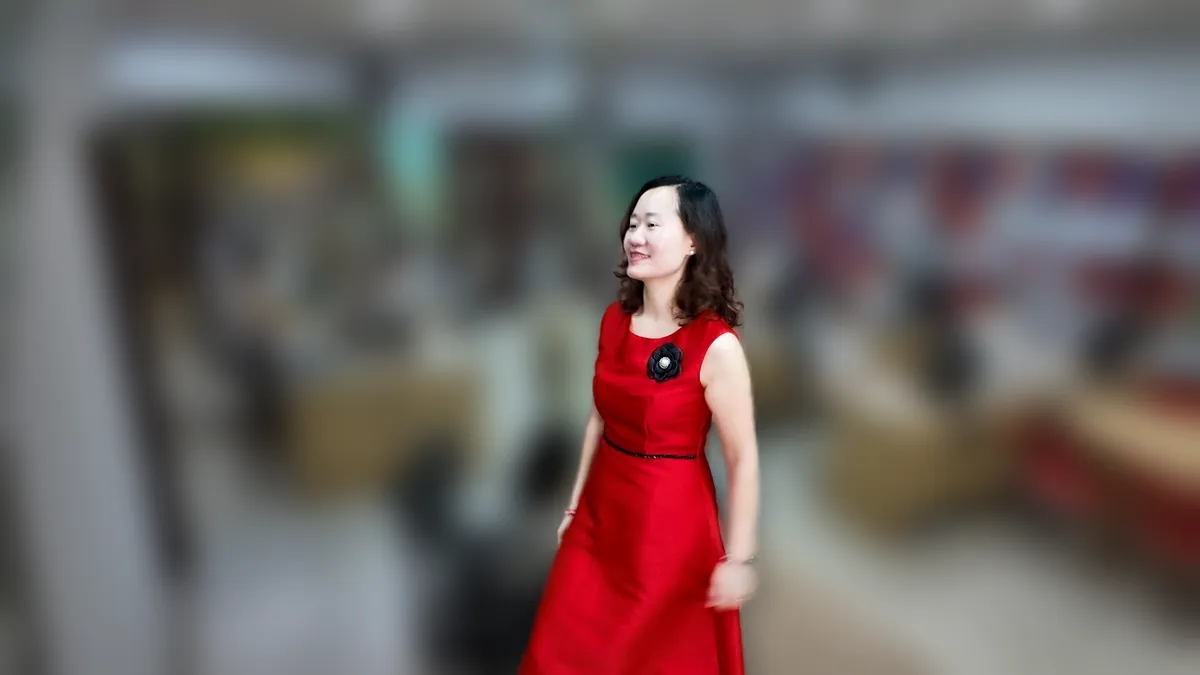 Chị Thảo Nguyễn váy đỏ đứng thẳng mỉm cười tại văn phòng Tâm - Tầm - Tài – chia sẻ về chi phí thành lập công ty