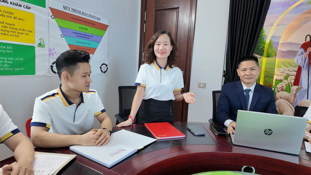 Thảo đứng hướng dẫn, nhân viên nam và anh Nguyễn Quốc Huy ngồi nghe