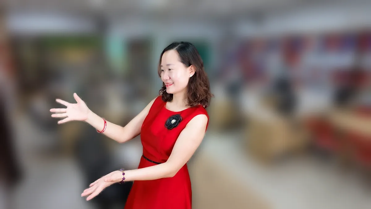 Chị Thảo Nguyễn váy đỏ đưa tay như giới thiệu, mỉm cười tại văn phòng Tâm - Tầm - Tài – chia sẻ về đăng ký kinh doanh cần gì
