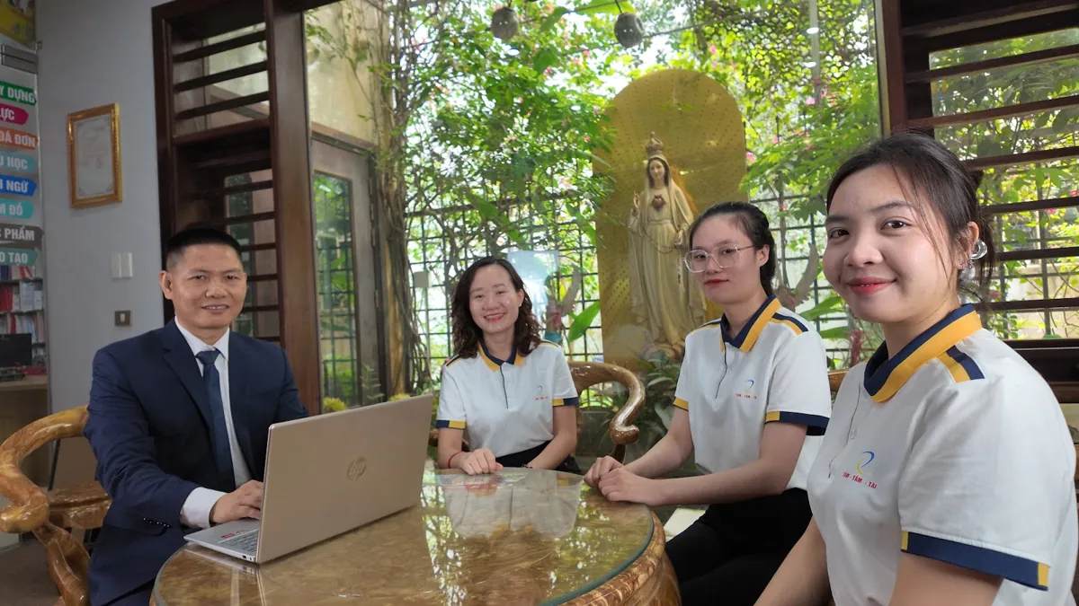 Anh Nguyễn Quốc Huy ngồi laptop cùng chị Thảo và nhân viên, nhìn ống kính tại Tâm - Tầm - Tài – Đăng ký kinh doanh online dịch vụ công