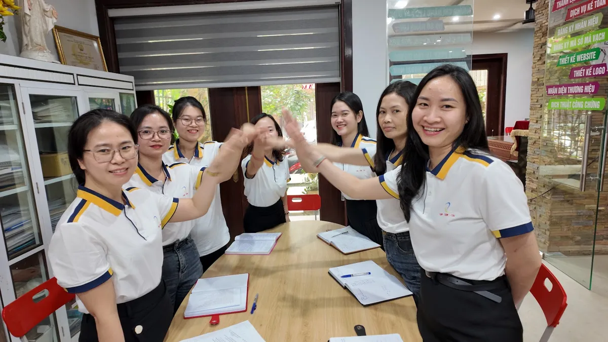 Đội ngũ nhân viên chồng tay đoàn kết quanh bàn họp
