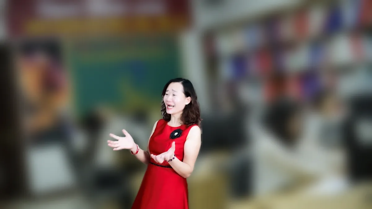 Chị Thảo Nguyễn váy đỏ cầm điện thoại, đứng mỉm cười tại văn phòng Tâm - Tầm - Tài – chia sẻ về thành lập công ty thương mại