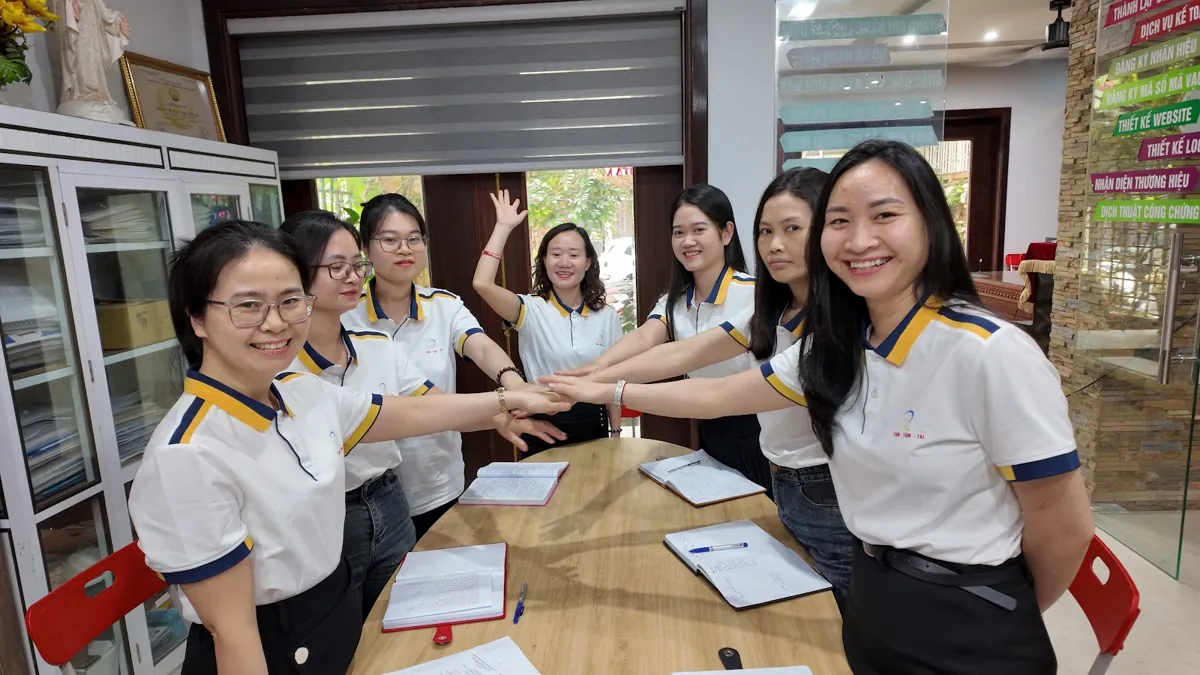 Đội ngũ nhân viên chồng tay đoàn kết quanh bàn họp tại Tâm - Tầm - Tài – Thảo nguyễn tâm tầm tài