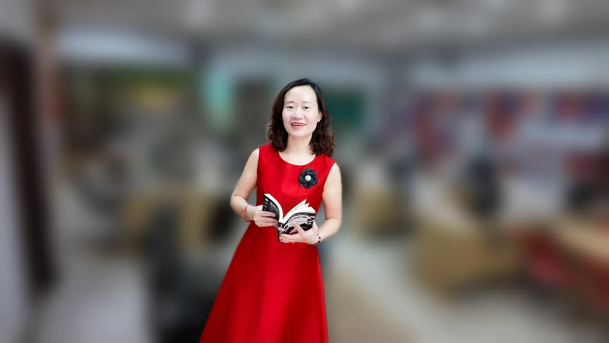 Thảo váy đỏ cầm điện thoại, đứng mỉm cười tại văn phòng Tâm - Tầm - Tài tại văn phòng Tâm - Tầm - Tài